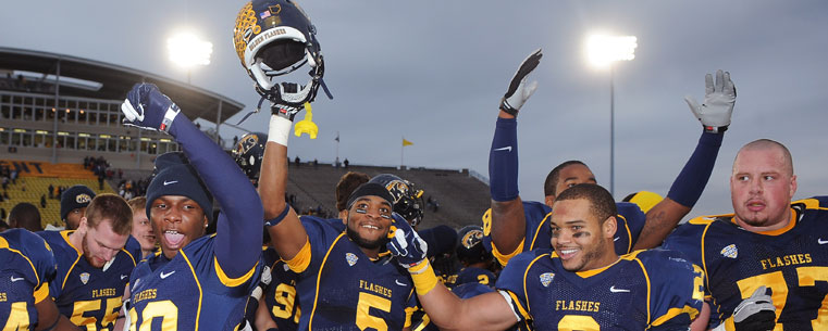 Kent State players celebrate on the field after going undefeated in the month of November.