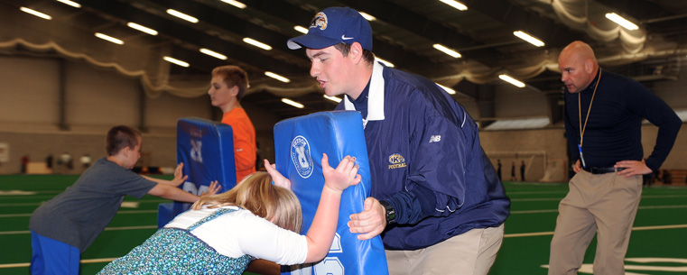 Kent State coaches run drills for kids attending the football clinic in the Kent State Field House, a part of the Meet-and-Greet Day for employees of Kent State and Ohio College of Podiatric Medicine and their families.