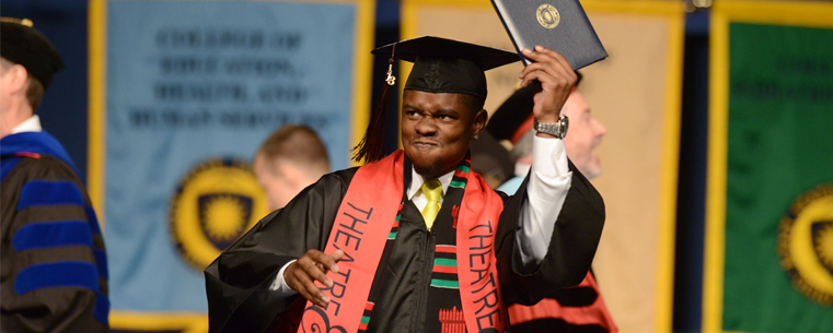 <p>A Kent State graduate celebrates during the morning commencement ceremony.<br />
</p>