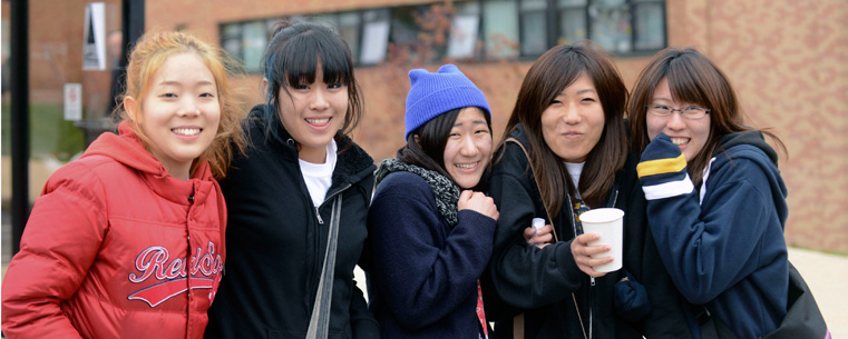 Kent State international students brave the rain and cold of Homecoming to view the Homecoming parade.