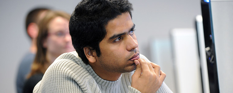 A student listens intently to a professor in Kent State’s School of Journalism and Mass Communication.