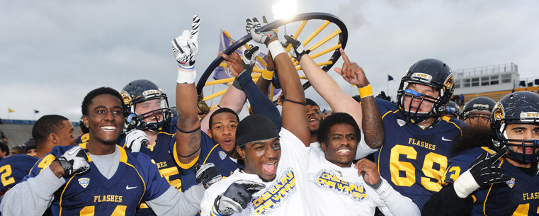 Kent State players charge onto the field to celebrate with the Wagon Wheel Trophy, after defeating the University of Akron 35-24 at Dix Stadium.