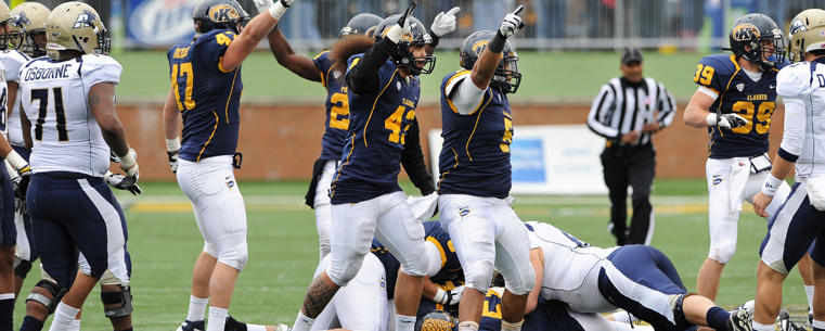 Kent State players celebrate a critical fumble recovery in the second half, against the University of Akron.