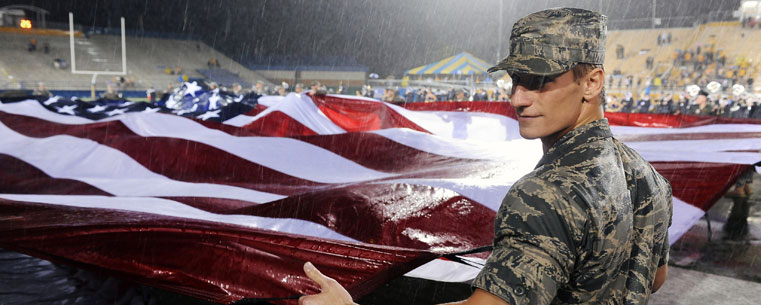 A member of the Kent State Air Force ROTC helps hold a large American flag during the halftime Heroes' Night commemoration during a home football game at Dix Stadium.