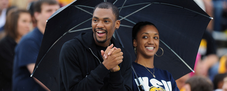 <p>Two Kent State fans watch the game under an umbrella.<br />
</p>