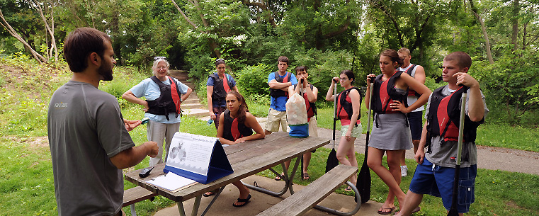 <p><font><font size="2">Participants review safety considerations before climbing into their canoes and kayaks for an adventure on the Cuyahoga River in downtown Kent, Ohio.</font></font></p>