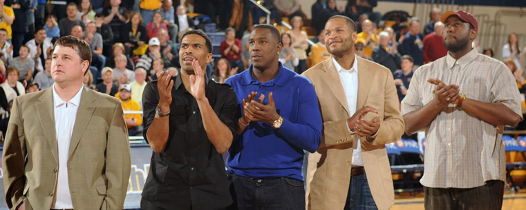 Members of the 2002 Elite Eight basketball team, including Antonio Gates and Demetric Shaw, reunite on the floor of the Memorial Athletic and Convocation Center, during a game against the College of Charleston.