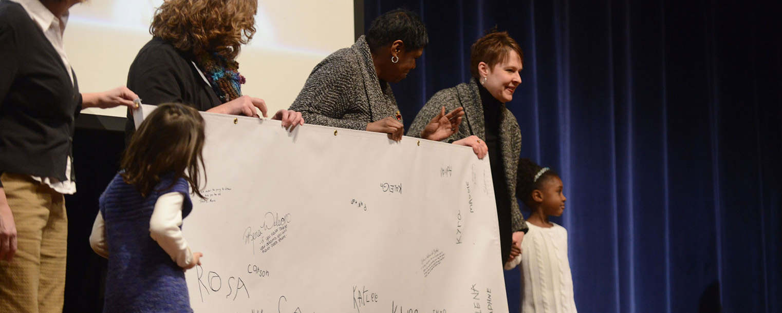 Children and representatives of Kent State's Child Development Center hold a banner signed by the children at the university's Martin Luther King Jr. Celebration.