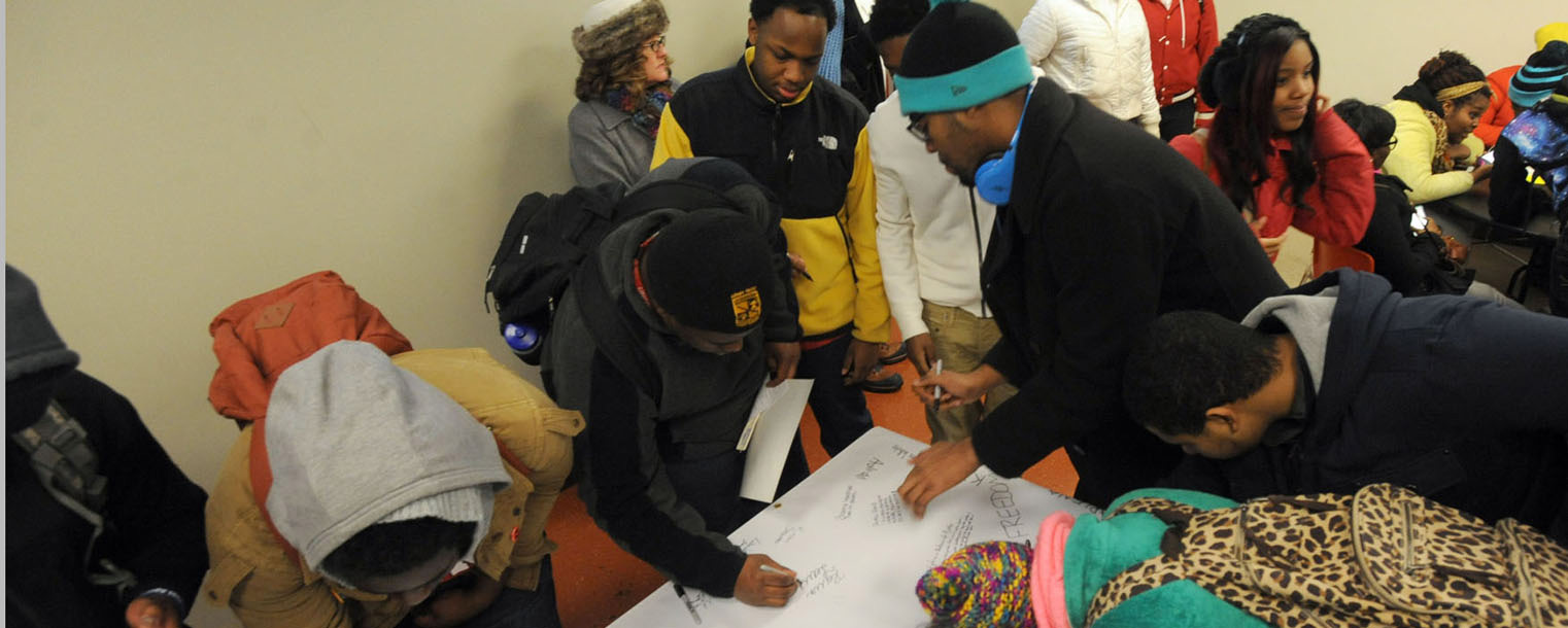 Kent State students sign the banner after a quick program in Ritchie Hall as part of the university's Martin Luther King Jr. Celebration.