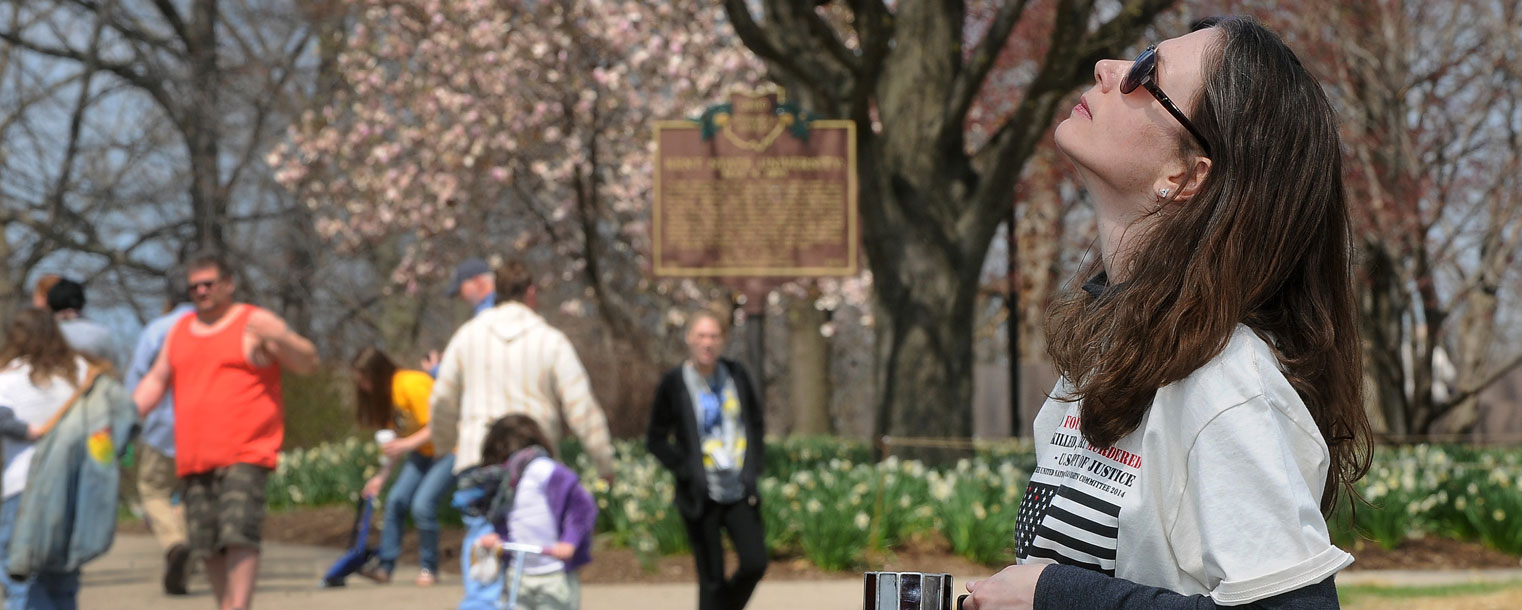 A relative of Allison Krause looks to the sky while standing in silent vigil on the location in the Taylor Hall parking lot, on the campus of Kent State University, where Krauss and three others were killed during the May 4, 1970, shootings by Ohio National Guardsmen.