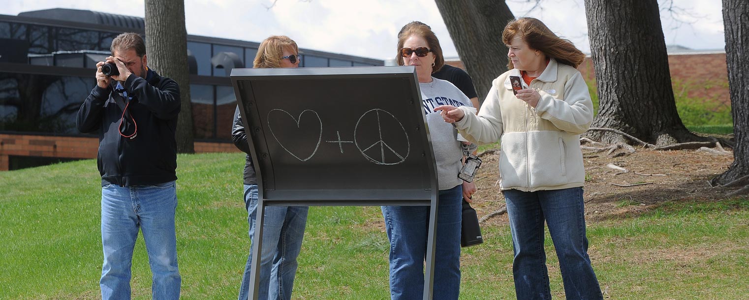 Visitors to the campus of Kent State University review historical information regarding the shootings of May 4, 1970, by Ohio National Guardsmen during anti-war protests.