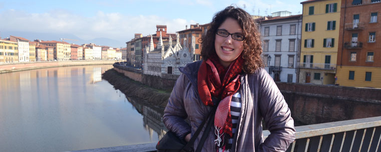 Kent State University student Lydia Coutré stands on a bridge over the Arno River in Pisa, Italy, near the Santa Maria dellaSpina Church.