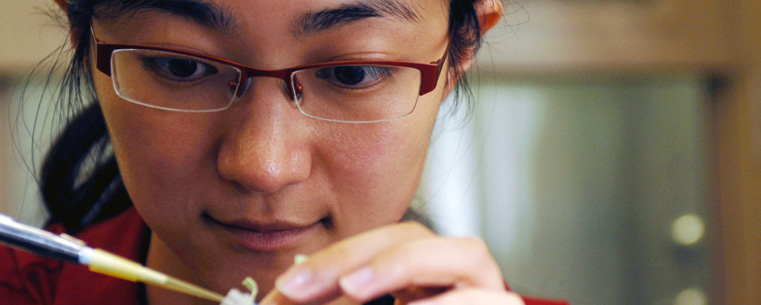 <p>A student majoring in biomedical sciences conducts an experiment in Cunningham Hall.</p>