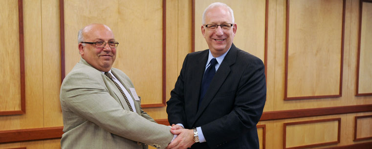 Dr. Vidas Lauruska, rector of Siauliai University, and Kent State University President Lester A. Lefton shake hands after signing an agreement between the two universities.