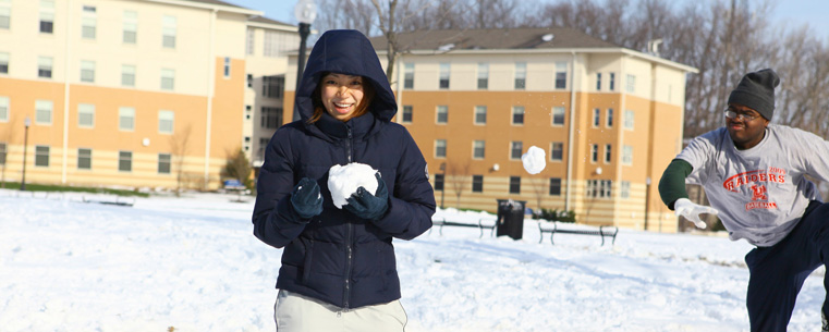 Students have a snowball fight near Centennial Court.