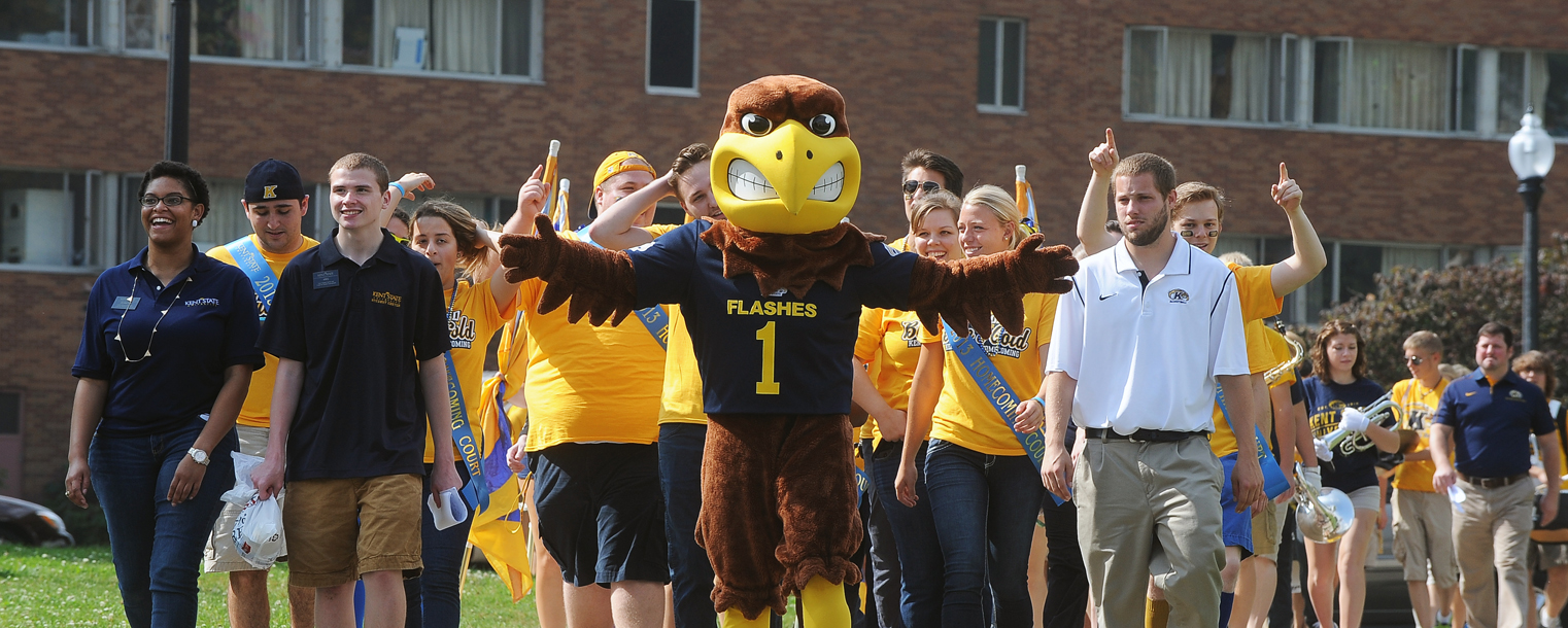 Kent State University's mascot "Flash" leads the way toward Tri-Towers as the Kent State Marching band, as well as members of the university community, walk across campus, collecting participants for the Homecoming pep rally, held on the Student Green.