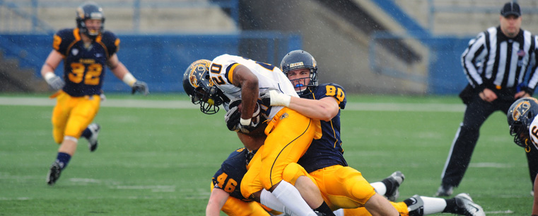 Defensive end Andrew Christopher brings down running back Larry Dawson during the Kent State Football Spring Game at Dix Stadium.