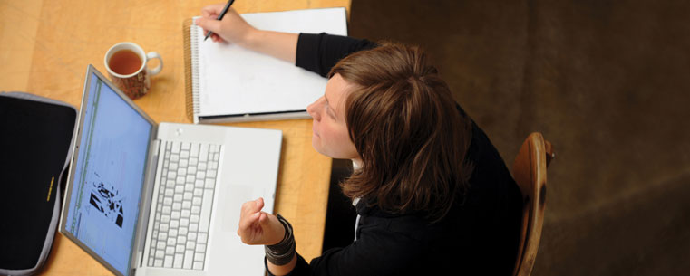 A Kent State student takes notes during a class in the Art Building.