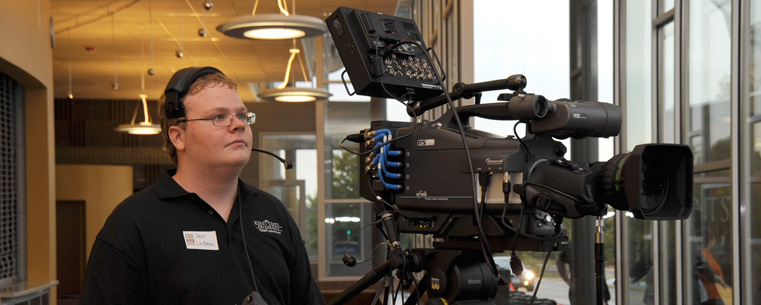 A TeleProductions employee works one of their video cameras in the lobby of the new Roe Green Center during its recent 50th anniversary open house.