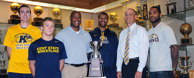 (left to right) Kent State’s Samuel Allen, Mack McGuire, head football coach Paul Haynes, Devareaux Manley, Director of Athletics Joel Nielsen and Tyshon Goode gather around the 2012-13 Reese Trophy in the Memorial Athletic and Convocation Center.