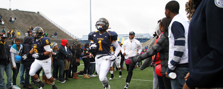 Students participating in Inspiration Day help form a tunnel as the Kent State Golden Flashes football team took to the field at Dix Stadium for the game against the University of Akron.