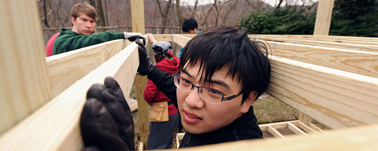 Kent State student volunteers work on the construction and repair of playground equipment in East Liverpool during a Kent State alternative spring break trip.