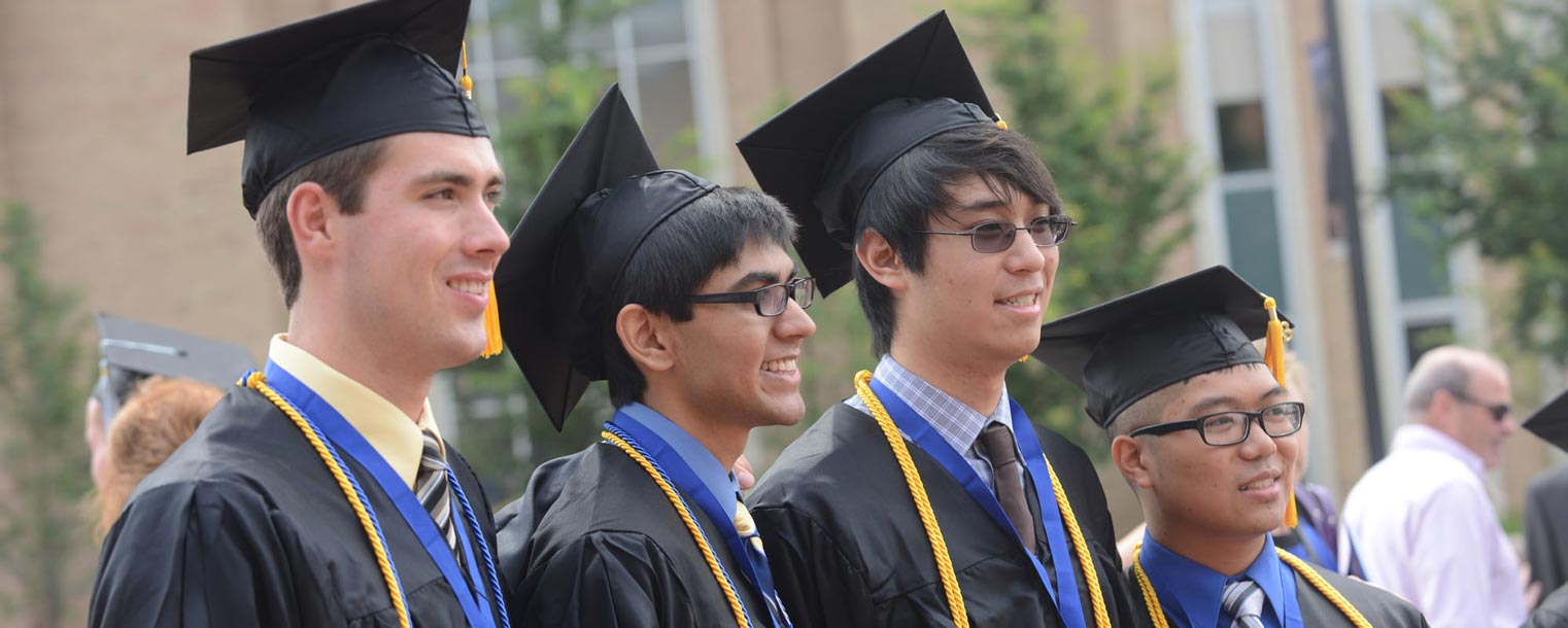 <p>Four Kent State students pose for a group photo on Risman Plaza after their Commencement ceremony.</p>