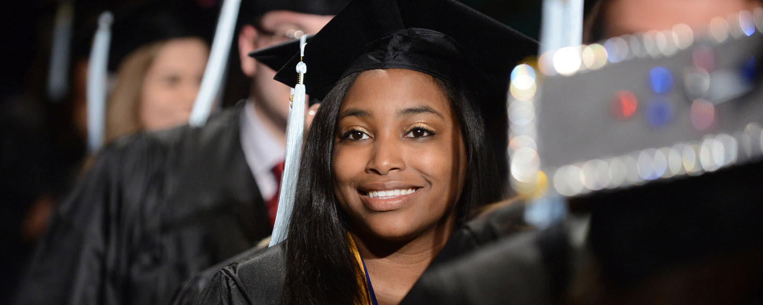 <p>A Kent State student smiles during the Spring 2013 Commencement ceremony.</p>