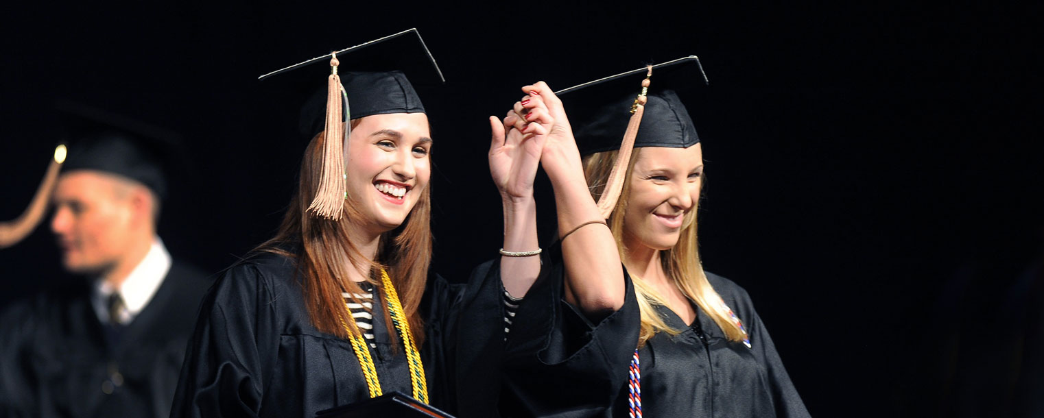 <p>Two friends hold hands in a victory pose after graduating from Kent State.<br />
</p>