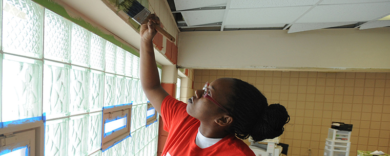 A Kent State student puts the finishing touches on the walls of the King Kennedy Community Center in Ravenna, Ohio.