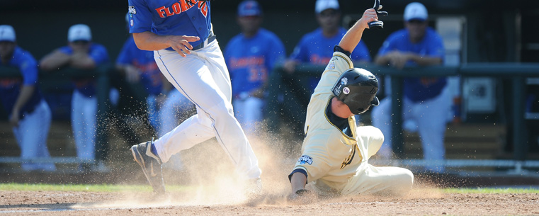 Kent State's Jimmy Rider scores on a wild pitch by Florida Gator Hudson Randall during the fourth inning.