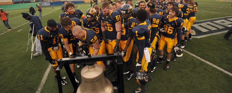 Members of the Kent State football team ring the Starner Victory Bell at the end of the final home game against Ohio University.