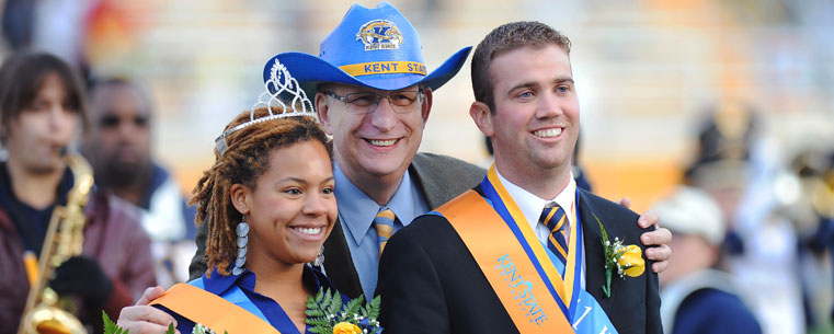 Ivy Lumpkin and Brady Ruffer, 2011 Homecoming Queen and King, are all smiles as they pose for photos with President Lester A. Lefton during halftime ceremonies at Dix Stadium.