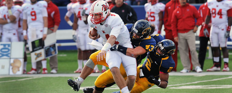 Kent State linebacker C.J. Malauulu (43) and defensive back Josh Pleasant (2) sack the Miami Redhawks quarterback during the first half of the Homecoming game at Dix Stadium.