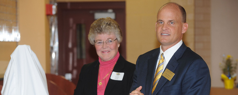 Director of Athletics Joel Nielsen presents a gift to Judy Devine at the dedication of the Athletic Resource Center in the Memorial Athletic and Convocation Center.