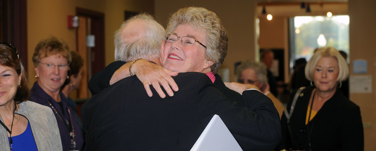 Emeritus Professor and donor Judy Devine hugs former Athletic Director Laing Kennedy at the dedication of the Athletic Resource Center in the Memorial Athletic and Convocation Center.