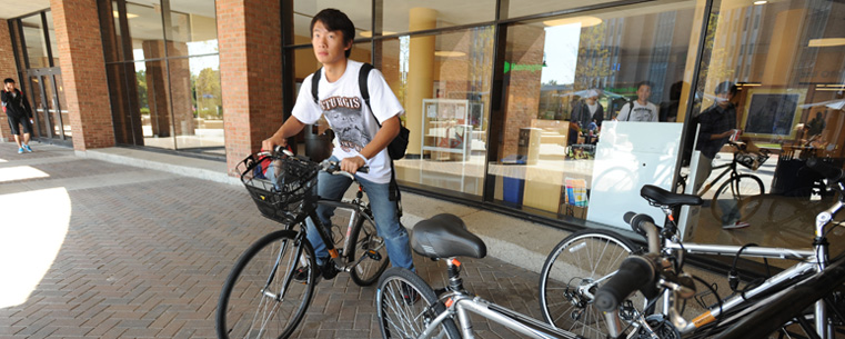 A student borrows a Flashfleet bike from the Kent Student Center. The bikes, which are free to use, must be returned to the original pick-up point.