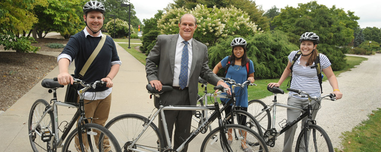 Dr. Robert Frank, provost, poses with students and some of the Flashfleet bikes.