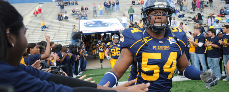 A fan greets a member of the Kent State Golden Flashes football team as they take the field for the 2009 game.