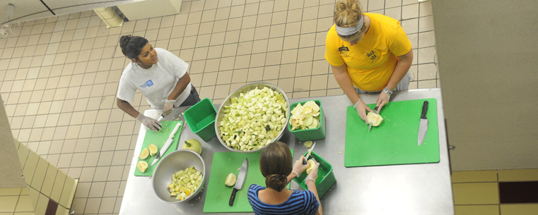 Kent State students chop vegetables in the kitchen in Beall Hall as part of the Campus Kitchen at Kent State.