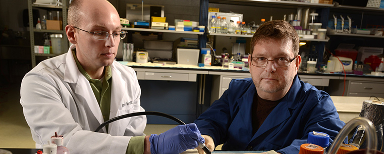 Kent State graduate student James Ferrell and Christopher Woolverton, Ph.D., professor of environmental health sciences, perform research in a lab at DeWeese Health Center.