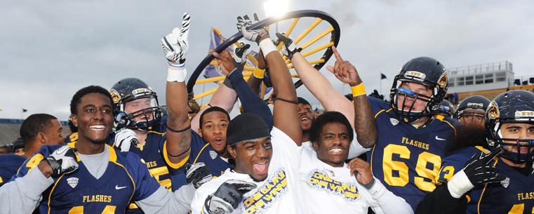 Members of the Kent State Golden Flashes football team hold the Wagon Wheel up after their victory over the University of Akron.