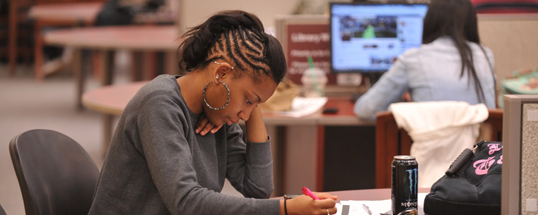 A Kent State student studies on the first floor of the library.