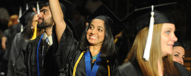 A summer 2011 graduate from the College of Arts and Sciences waves to her family during commencement.