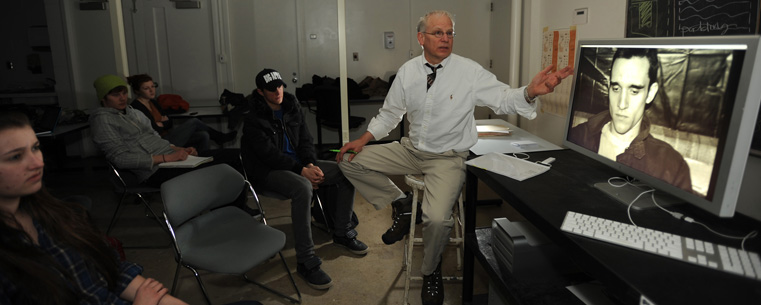 <p>Chris Ransom, an associate professor in visual communication design, goes over student work during a photographic illustration class in the Art Building.<br />
</p>